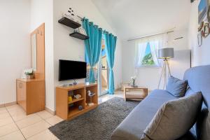 a living room with a couch and a tv at Villa Mare Komiža in Komiža