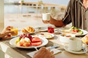 un grupo de personas sentadas en una mesa con comida en Arrecife Gran Hotel & Spa, en Arrecife