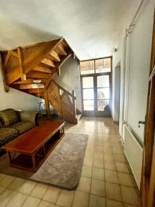 uma sala de estar com um sofá e uma escada em VillaPark Garden House em Szerencs
