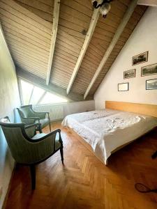 a bedroom with a large bed and a chair at VillaPark Garden House in Szerencs