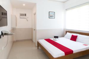 Un dormitorio con una cama con una manta roja. en Softwind Villa Hotel and Resort en Santa Catalina