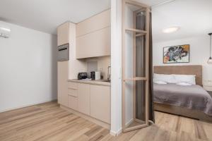 małą sypialnię z łóżkiem i kuchnią w obiekcie Apartment Wow w mieście Rijeka