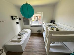 a room with two bunk beds and a green lantern at Haus am See in Barßel