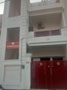 um edifício branco com portas vermelhas e um portão vermelho em Maa vaishno paying guest house em Ayodhya