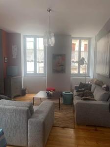 a living room with a couch and a table at Grand appartement 2 à 8 personnes in Cauterets