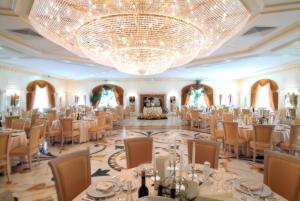 a banquet hall with tables and chairs and a chandelier at Park Hotel Campitelli in Larino