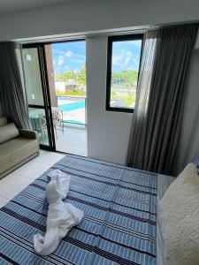 ein Hotelzimmer mit einem Bett mit Handtüchern darauf in der Unterkunft Makia Beach Experience Muro Alto Porto de Galinhas in Porto De Galinhas
