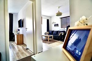 een woonkamer met een televisie en een woonkamer met een bank bij Relaxing Coresi Place in Braşov