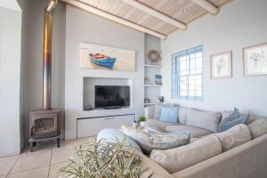 a living room with a couch and a tv at Tides Holiday Home in Paternoster