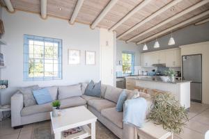 a living room with a couch and a kitchen at Tides Holiday Home in Paternoster