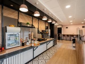 a large kitchen with a counter with food on it at B&B HOTEL Lorient Ploemeur in Ploemeur