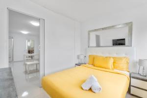 a bedroom with a yellow bed and a mirror at Costa del Silencio Tenerife Sur in Arona