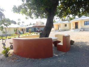 un árbol con un banco y una mesa bajo un árbol en Wajiji Homes en Mtwapa