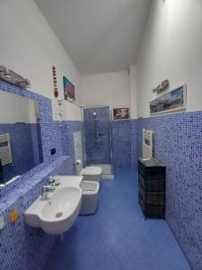 Baño de azulejos azules con 2 aseos y lavamanos en "La Casita", 2 Floors Apartment, Private Parking 1 car OR 2 Bikes, Air-Cond and Terrace, en Livorno