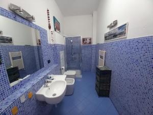 W wyłożonej niebieskimi kafelkami łazience znajdują się 2 toalety i umywalka. w obiekcie "La Casita", 2 Floors Apartment, Private Parking 1 car OR 2 Bikes, Air-Cond and Terrace w mieście Livorno
