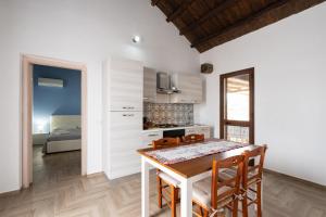 a kitchen and dining room with a table and chairs at Villa Siciliana con piscina privata in Buseto Palizzolo