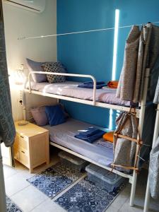 two bunk beds in a room with a blue wall at Casa Amari alla Zisa HOSTEL in Palermo