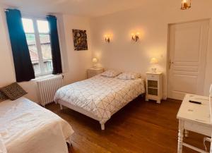 a bedroom with two beds and a window at Le Commerce in Tramayes