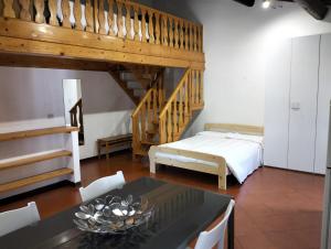 uma sala de estar com uma cama, uma mesa e uma escada em Appartamenti Frescobaldi em Ferrara