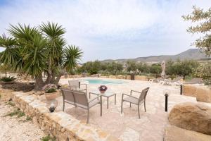 a patio with a table and chairs next to a pool at Villa Siciliana con piscina privata in Buseto Palizzolo