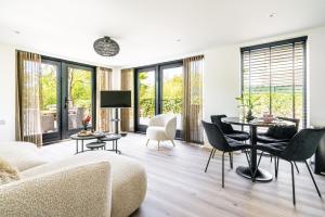 a living room with a couch and a table and chairs at Nieuw vakantiehuis Domburg, in centrum dichtbij strand in Domburg