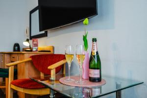 a table with two glasses of wine and a bottle of champagne at Hotel Bristol in Kielce