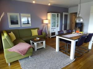 達默的住宿－Gode Wind Quartiere 4，客厅配有绿色沙发和桌子