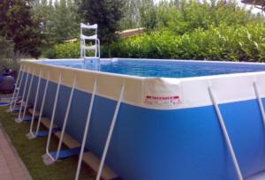 una gran piscina azul y blanca con una escalera alrededor en Dolce Dormire Home Holiday, en Castellammare del Golfo