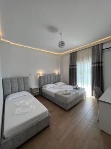 una camera d'albergo con due letti e un divano di Vila Melina a Ksamil