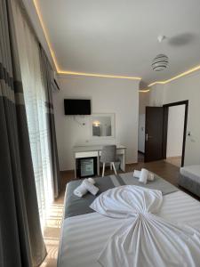 a bedroom with a large white bed with towels on it at Vila Melina in Ksamil