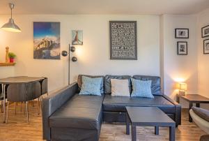 een woonkamer met een bank en een tafel bij Apartment Grepon 3A - A Central Chamonix Haven in Chamonix-Mont-Blanc