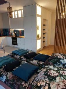 a bedroom with four pillows on a bed at Apartament Cień Wiatru z Widokiem na Jezioro i Netflixem in Charzykowy +10 photos