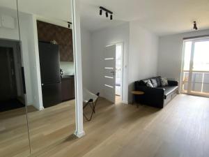 ein Wohnzimmer mit einem schwarzen Sofa und einem Spiegel in der Unterkunft Apartament Flow in Kłodzko