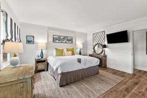 1 dormitorio con 1 cama grande y TV en Clam I Am en Grayton Beach