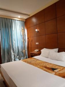 une chambre d'hôtel avec un lit et une fenêtre dans l'établissement Bau rivage hotel, à Akwa
