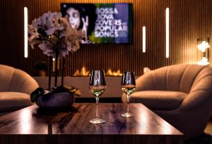 twee glazen wijn op een houten tafel met twee stoelen bij "l'Escape room" - love room atypique in Saint-Martin-des-Entrées