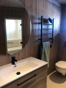 La salle de bains est pourvue d'un lavabo et d'un miroir. dans l'établissement Golsfjellet - new modern cabin with fantastic view, à Golsfjellet