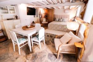 a bedroom with a bed and a table and chairs at Rustic house in Ano Syros in Ano Syros
