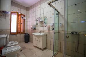 uma casa de banho com um chuveiro, um lavatório e um WC. em Terrace Hostel & Lounge Bar em Shkodër