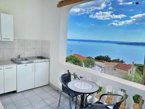 a kitchen with a table and a view of the ocean at Villa Stipuka in Brela
