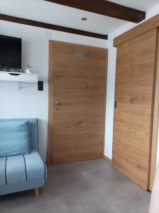 drewniane drzwi w pokoju z niebieską kanapą w obiekcie Ferienwohnung Innergreit w Alpbach