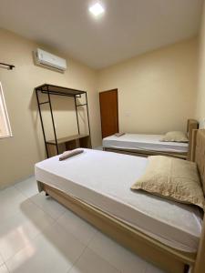 um quarto com 2 camas e uma ventoinha em Condomínio Farol das Dunas em Santo Amaro
