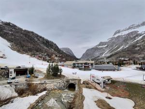 a small town with a bridge and snow covered mountains at Appartement Val-d'Isère, 4 pièces, 6 personnes - FR-1-411-682 in Val-d'Isère