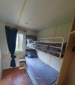伊哥勒頓的住宿－Camping du Lac，客房设有两张双层床和一扇窗户。