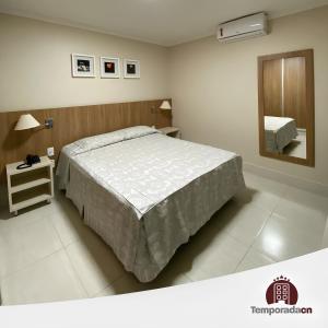 1 dormitorio con 1 cama grande y espejo en Piazza com acesso ao Acqua Park, en Caldas Novas