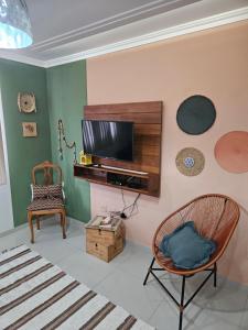 a living room with a television and a chair at casa/apartamento centro Santa Teresa-ES in Santa Teresa