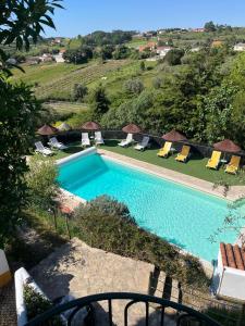 a swimming pool with lounge chairs next to at Quinta Laranja - Turismo Rural - in Alvorninha