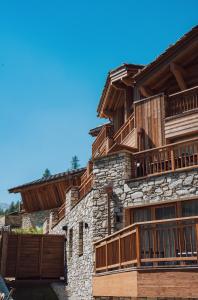 a building with wooden balconies on the side of it at Alaska Lodge by Alpine Residences in Val dʼIsère
