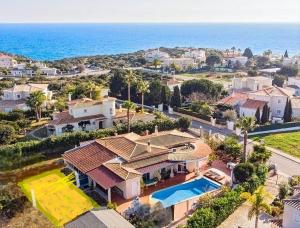 una vista aérea de una casa con piscina en Oceanfront Villa - 8 rooms, 2 kitchens with pool, billiard table and Beach-Volleyball Court, en Carvoeiro