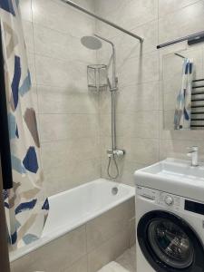 La salle de bains est pourvue d'une douche et d'un lave-linge. dans l'établissement Apartment in Tashkent City Center, à Yakkasaray